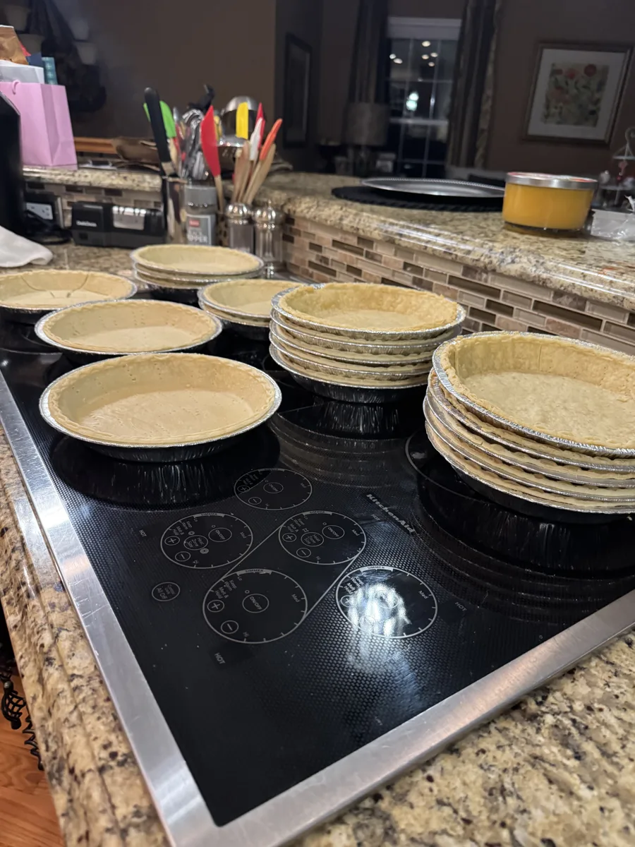 Queen Zuri pie crusts in foil tins on the kitchen cooktop